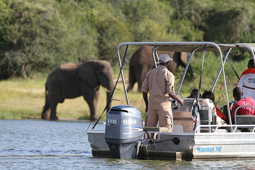 Tourists view elephants from a boat in Akagera National Park. / Courtesy
