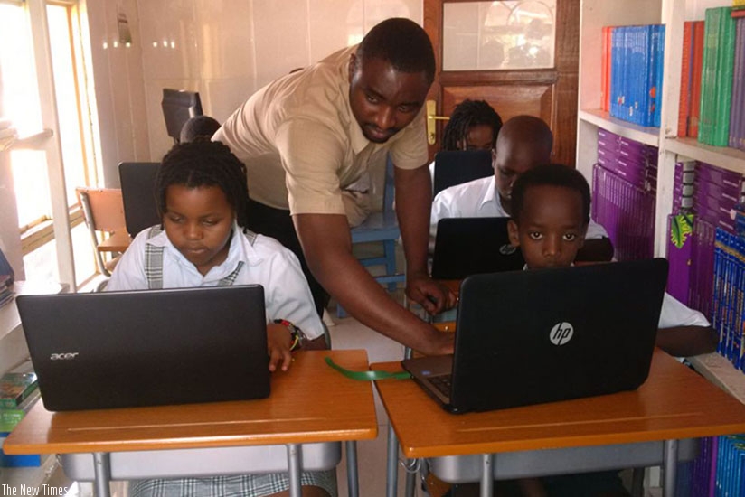A teacher at Little Bears guides his pupils during their computer class.