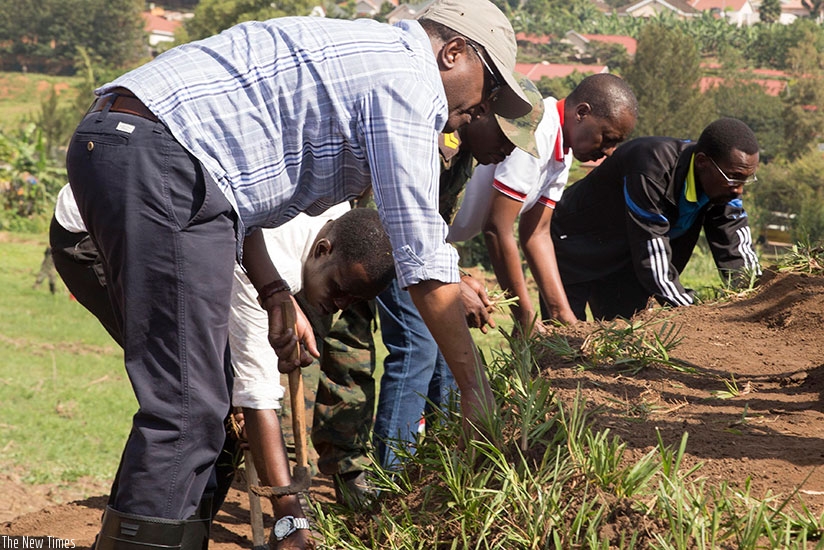 Dr Biruta and other officials plant grass during a special community exercise (Umuganda) last month at Nyandungu Wetland which is being developed into an Eco-Tourism Park. (Courtesy)