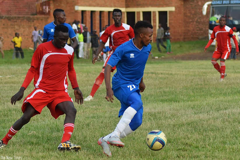Rayon Sports winger Dominique Savio Nshuti controls the ball under pressure from Espoir players at Kamarampaka Stadium in Rusizi on Sunday. (Sam Ngendahimana)