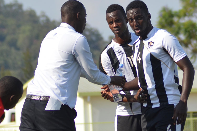 APR head coach Jimmy Mulisa hands bottles of water to his players in a past league match. (Sam Ngendahimana)