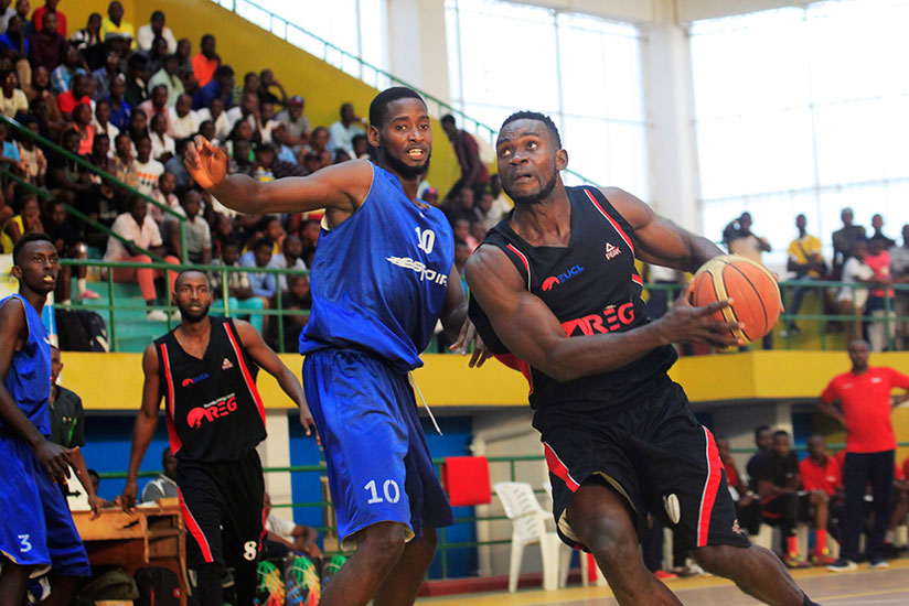 REG's Bienvenu Ngandu goes for points as Espoir captian Olivier Shyaka tries to block him during Genocide memorial tourney. / Sam Ngendahimana