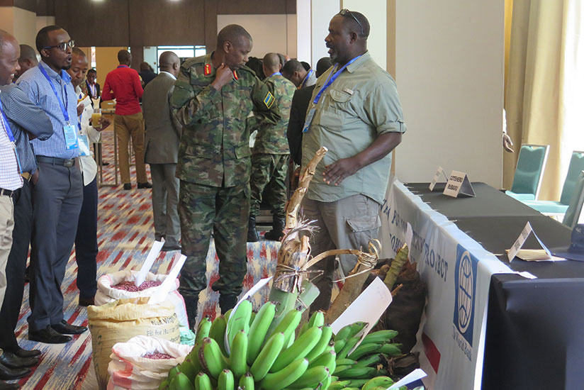 Gashugi (R) chats with other participants during the agricultural exhibition. / Eddie Nsabimana