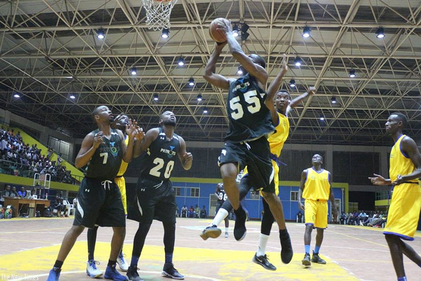 Patriot's center player Elie Kaje jumps in the air to drop two points as IPRC-Kigali players try to block him during game one on Friday. G. Asiimwe