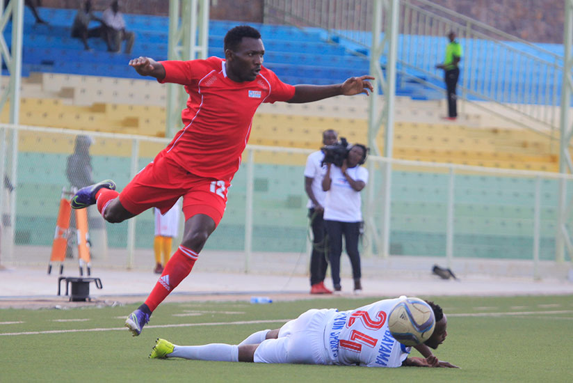 Espoir FC's Basile Hatungiman jumps over Rayon Sport's Nova Bayama during the second leg match of their semi final at Stade de Kigali last week. / Sam Ngendahimana