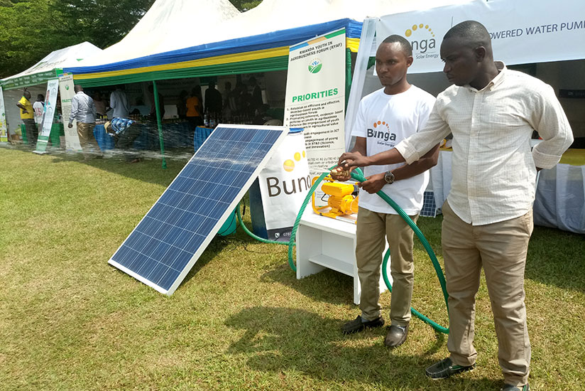 An exhibitor (L) and a farmer test a solar powered irrigation  Technology  at the agriculture  show, at Mulindi Show ground in Kigali on Friday. (Emmanuel  Ntirenganya)