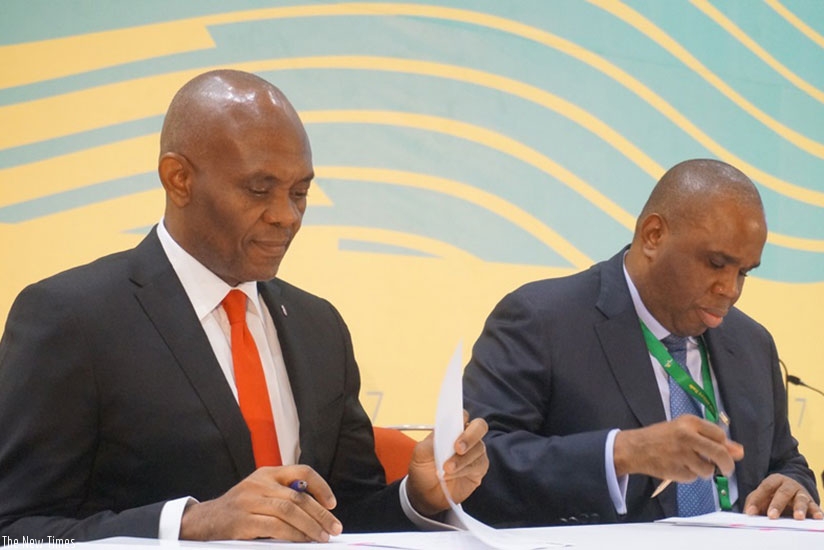 Elumelu (left) and Dr Benedict Oramah, the chairman of Afreximbank, sign a deal for $100 million credit facility to support Heirs Holdings. (Julius Bizimumgu)