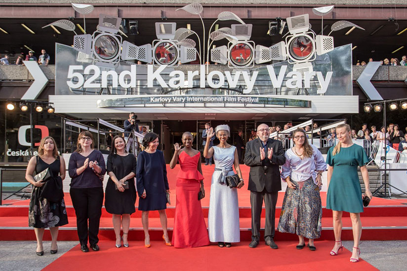 Rwandan actress Umuhire and Murenzi, the film's production designer and art director (in a sky blue gown), on the red carpet with other delegates at the Karlovy Vary International ....