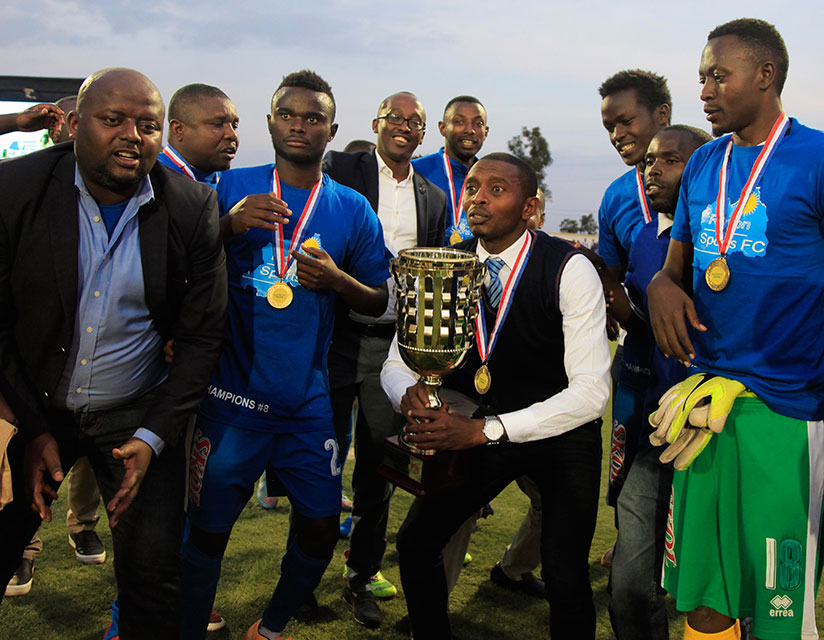 Masudi surrounded by his players prepares to raise the league trophy yesterday. / Photos: Sam Ngendahimana