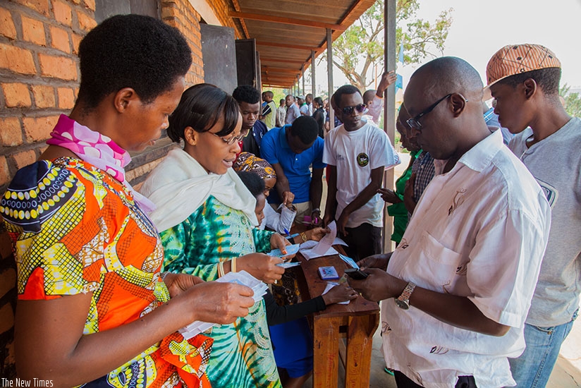 People collect their voter cards at Sainte Famille polling station during the 2015 referendum on the Constitution. Faustin Niyigena.