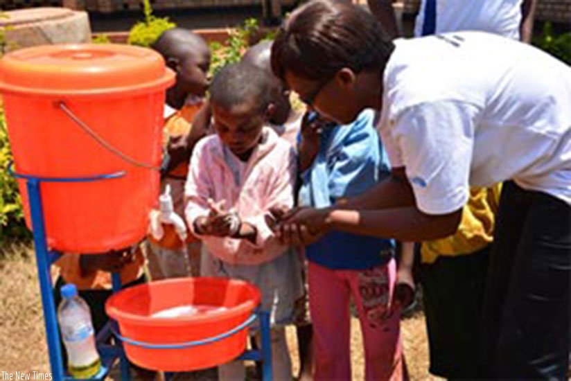 An elder helping and teaching children how to wash hands with soap at the ECD centre. (Courtesy photos)