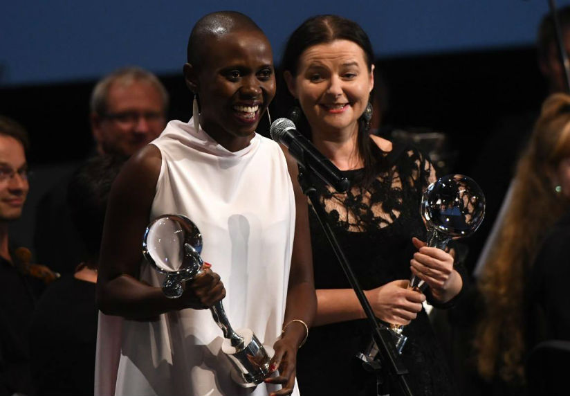 Excitement and shock on Eliane Umuhire's face as she accepts her award at the KVIFF 2017. The Rwandan actress is flanked by Joanna Kos-Krauze, a prominent Polish writer-director , ....