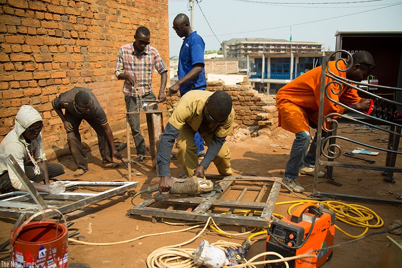 The entrepreneur (foreground) with some of his employees at his workshop in Gihundwe.  / All photos: Timothy Kisambira