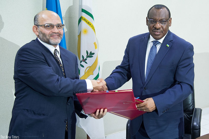 WB's Gammal (L) exchanges documents with minister Gatete after the signing ceremony in Kigali. / Timothy Kisambira. 