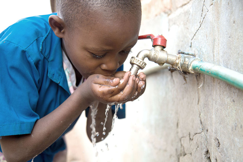 A school child in Muhanga District drinks water. More than 85% of Rwandans have access to clean water. (Timothy Kisambira)