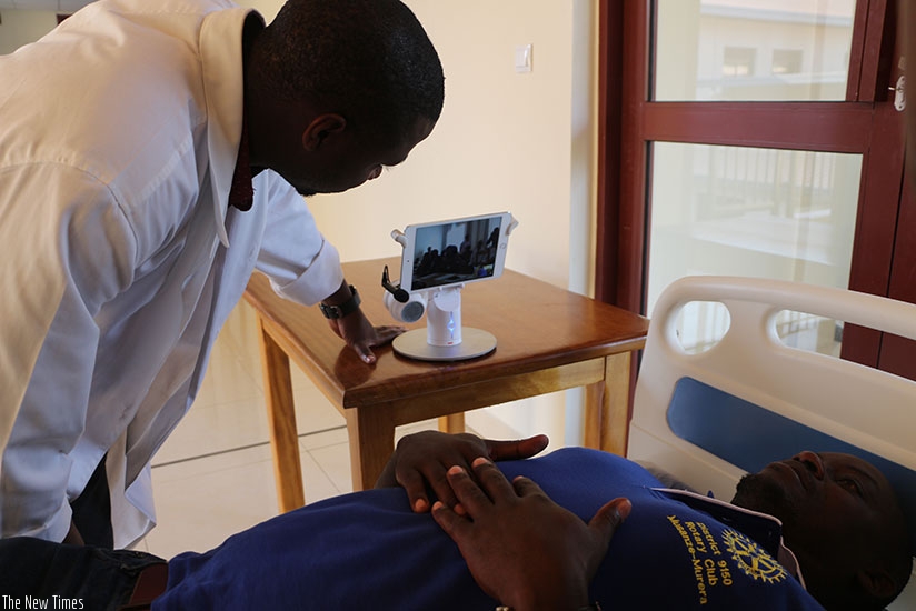 A doctor attending to a patient at a local health facility seeks another doctor's opinion by use of  telemedicine technology. Michel Nkurunziza. 
