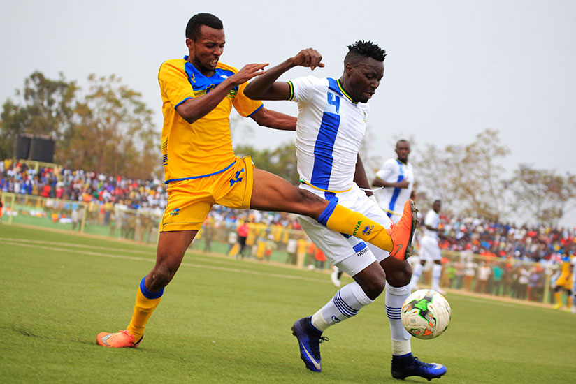 Amavubi forward Savio Dominique Nshuti (L) battles for ball with Tanzanian defender Erasto Nyoni at Kigali Stadium yesterday. / Sam Ngendahimana