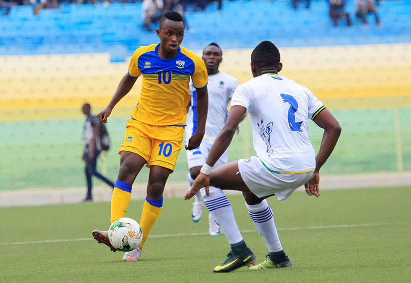 Amavubi youngster Kevin Muhire (left) controls the ball as he tries to go past Tanzanian defender Micheal Kamagi during the match on Saturday. / Sam Ngendahimana