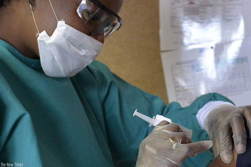 A medical practitioner administers a vaccine.  Net.