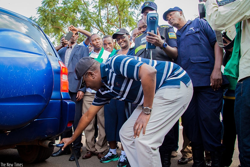 Natural Resources minister Dr Vicent Biruta tests levels of carbon emissions from a car as police officers verify if the results match with the environmental standards. File. 