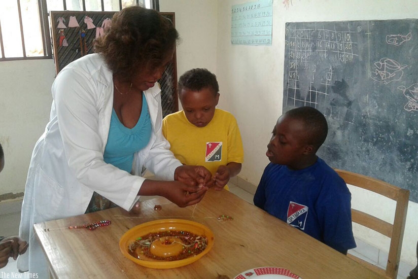 a teacher helping out a child with special needs at HVP Gatagara