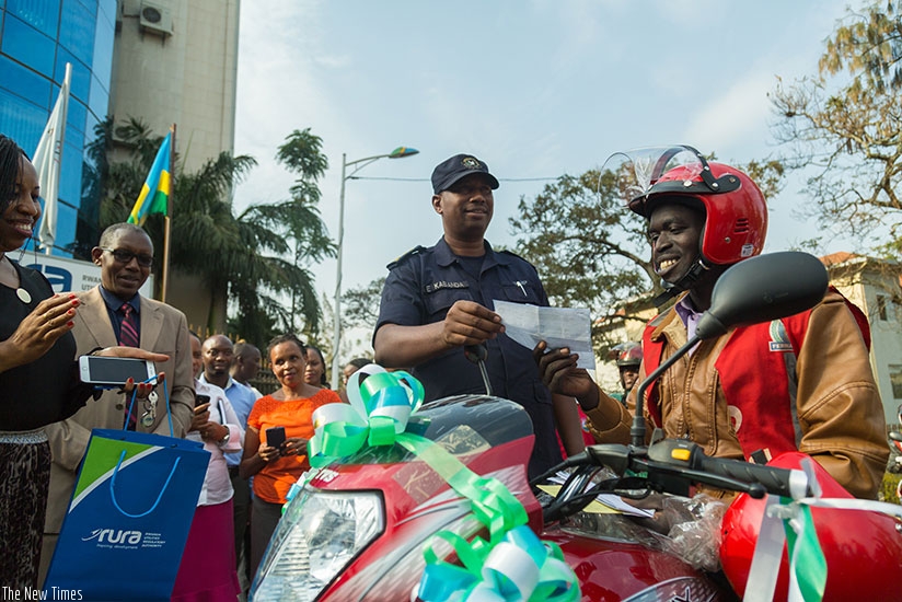 Traffic Spokesperson and Chief Inspector of Police Emmanuel Kabanda, gives motor Insurance to Donat Ndayiramiye. 