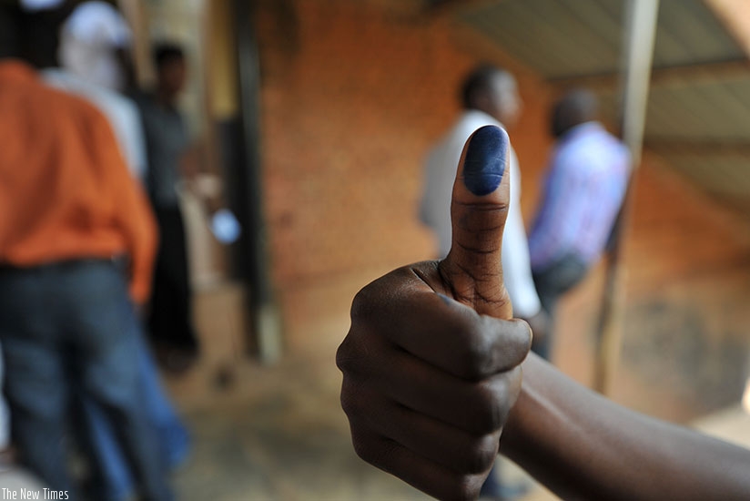 A voter shows his thumbs with ink after voting in 2013 elections. File 