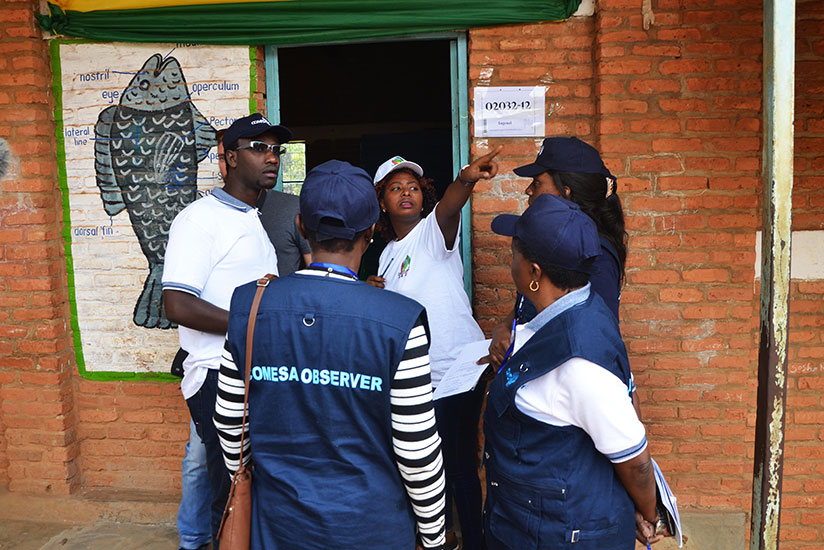 An electoral volunteer talks to COMESA observers at Groupe Scolaire Kimironko II polling station in Gasabo District yesterday. rn