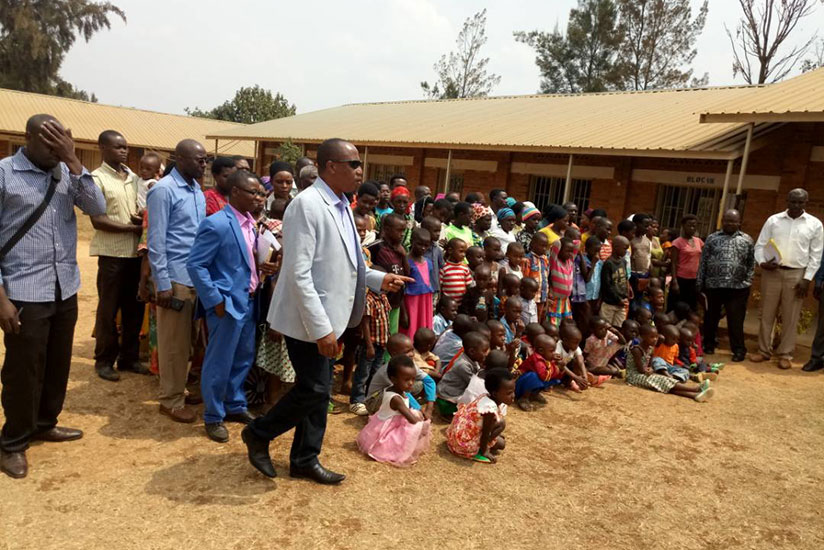 Pastor Ntavuka talks to mutuelle de sante beneficiaries before they received them. / Jean d'Amour Mbonyinshuti