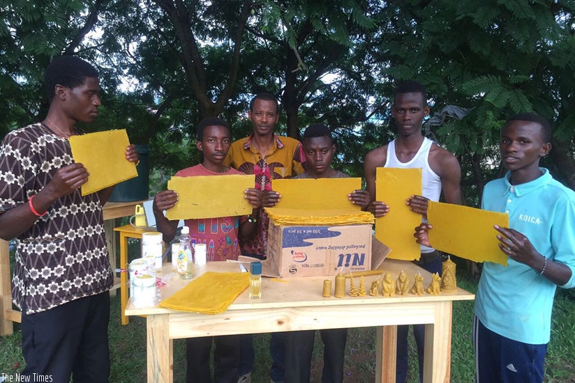 Kanimba (middle) and some of the trainees demonstrate how to make candles from bee wax. The enterprising youth also makes honey (below) among other products. / Photos: Frederic Byumvuhore.