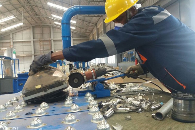 A technician examines an old TV. The Bugesera-based project refurbishes electronic and solid waste. / Michel Nkurunziza.