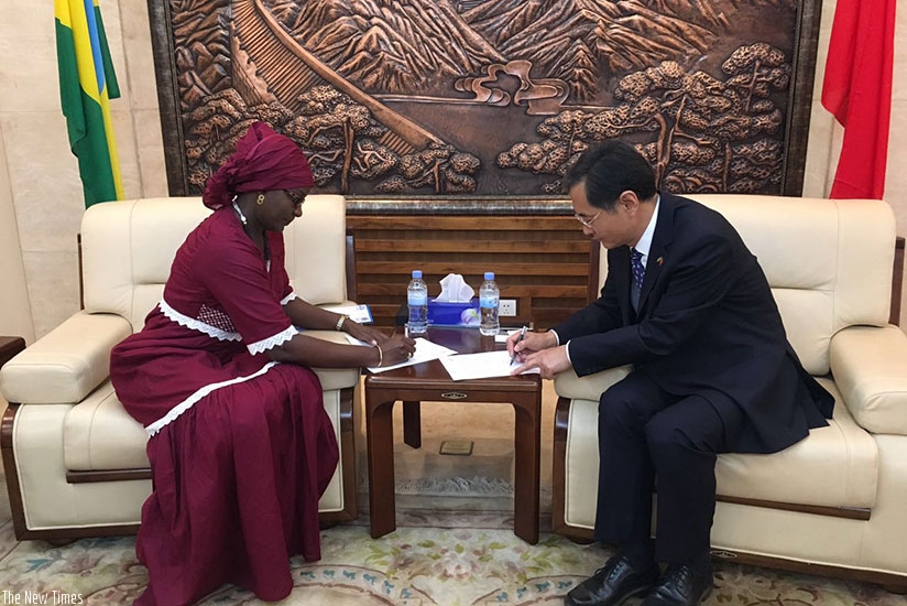 Fatou Aminata Lo, the country representative of UN Women (L) and Chinese ambassador to Rwanda Rao Hungwei sign the documents for the grant. 