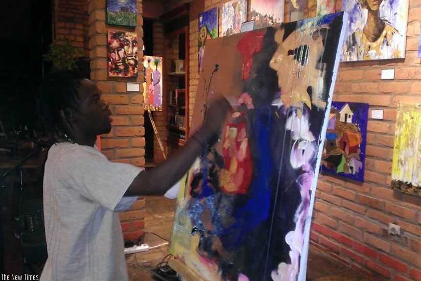 Artist Willy Karekezi demonstrates how live painting is done during the opening of his exhibition at the Heaven Restaurant on Saturday.  Moses Opobo.