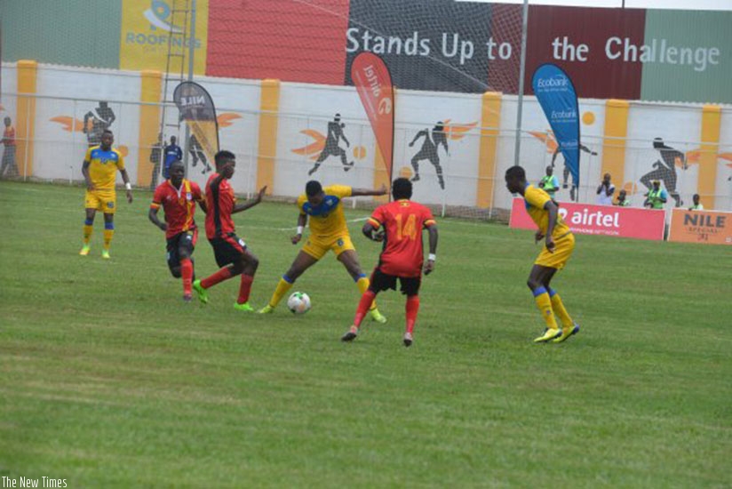 Amavubi player, Yannick Mukunzi tries to go pass the Uganda players in the first leg. Courtesy