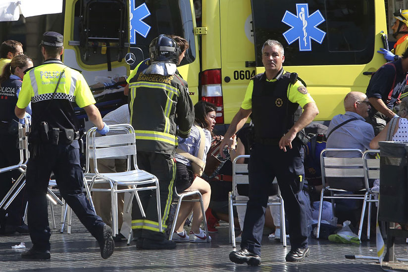 Injured people are treated in Barcelona after a van jumped the sidewalk in the historic Las Ramblas district, crashing into a summer crowd of residents and tourists, police said. /....