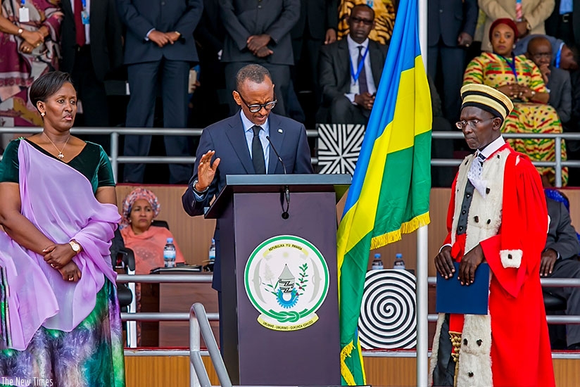 President Kagame takes oath administered by Chief Justice Sam Rugege (R) as First Lady Jeannette Kagame looks on at Amahoro National Stadium in Kigali yesterday. Village Urugwiro.