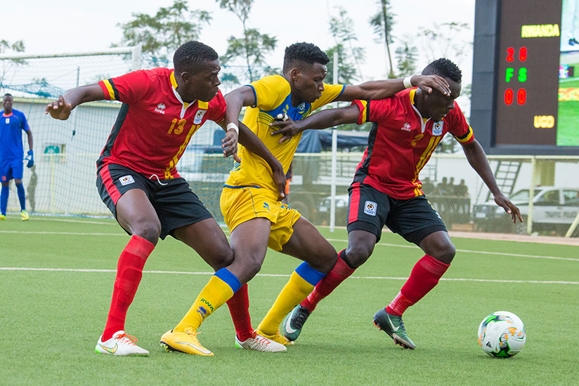 Amavubi striker Abeddy Biramahire fights for the ball with Cranes defenders during yesterday's 2-0 win over Uganda. Although Rwanda won the tie, they lost 3-2 on aggregate. / Timot....