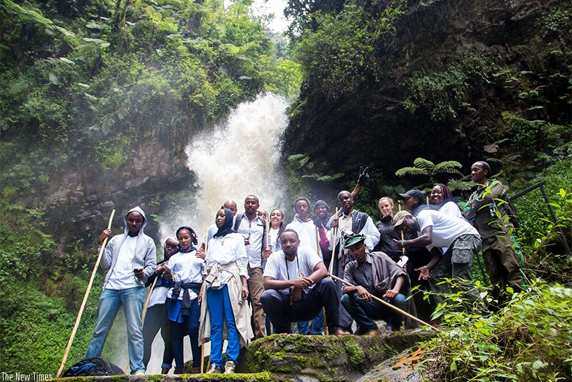Local and foreign tourists pose for a photo at the Kamiranzovu waterfalls in Nyungwe National Park. the firm will also market Rwanda as a tourist destination under the deal. File.