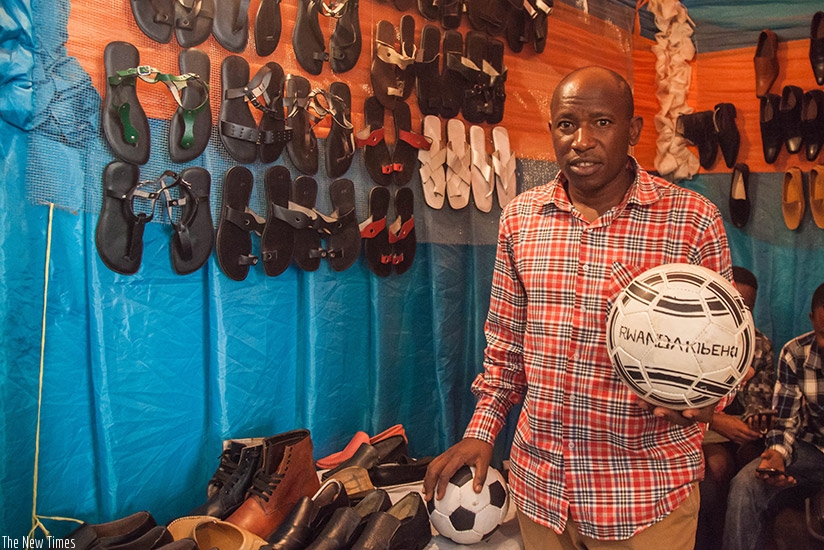 Simugomwa poses with the leather balls that are made in Rwanda. Nadege Imbabazi.