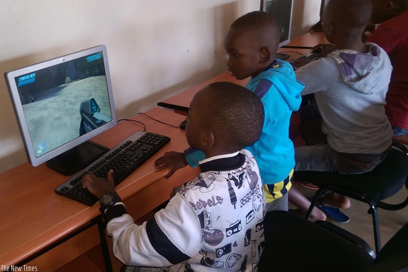 Young boys share skills on how to play computer games. Use the computer to search for educative information. (Dennis Agaba)