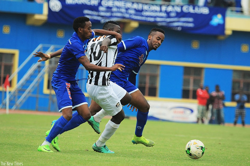 APR FC midfielder Muhadjiri Hakizimana vies for the ball with former teammates-turned-Rayon Sports' players Eric Rutanga (L) and Yannick Mukunzi  during their Agaciro tie at Amahor....