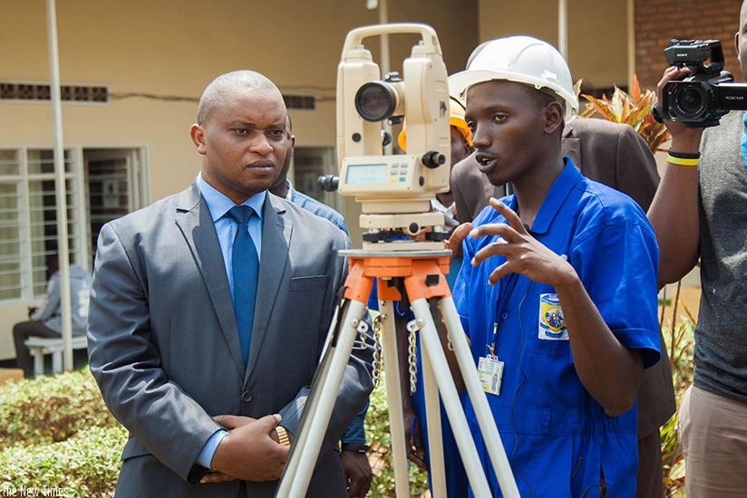 A student from Saint Joseph Integrated Polytechnic explains to Minister Rwamukwaya how to use total station during a practical exam yesterday. (Nadege Imbabazi)