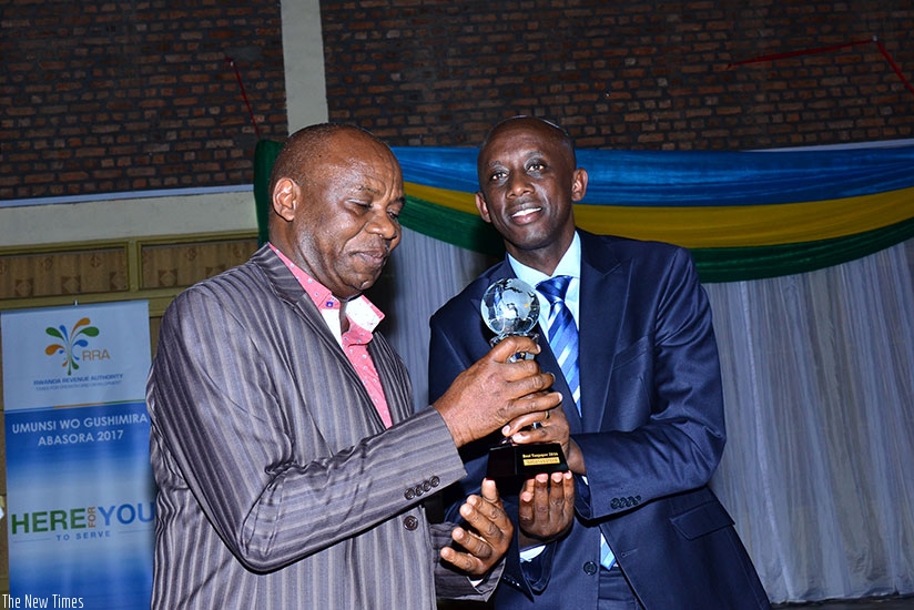Minister Kaboneka (R) awards one of the most compliant tax payers in Musanze. / Timothy Kisambira