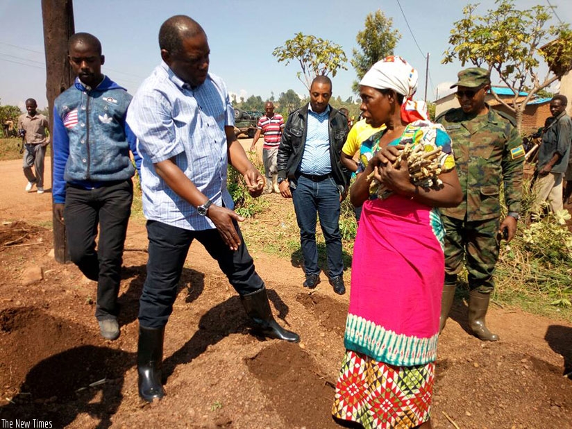Nsengiyumva shows farmers how to plant cassava stem cuttings at the launch of Season A. The Minister said the cuttings should  be planted horizontally, not vertically, for better r....