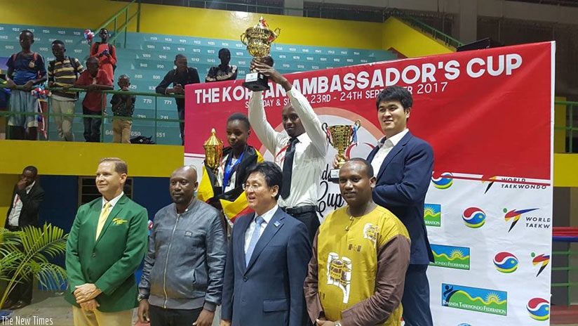 Dream Taekwondo Club coach Eugene Ntawangundi lifts winners' trophy after his team dominated the 2017 Ambassador's Cup. / J. Muhinde