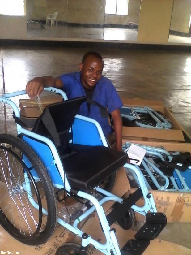 Habanabakize poses by a wheelchair he is making. / Jean d'Amour Mbonyinshuti