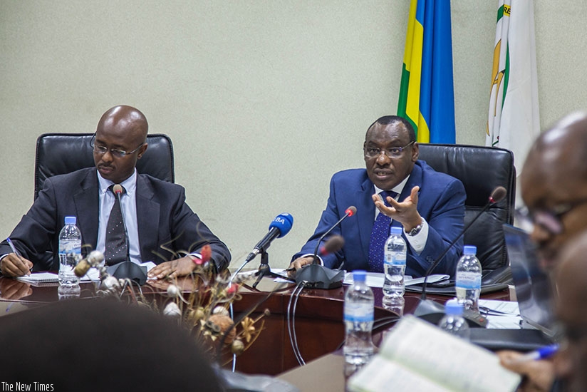 Finance and Economic Planning minister Claver Gatete (R) speaks as the National Institute of Statistics of Rwanda director-general Yusuf Murangwa takes notes during the presentatio....