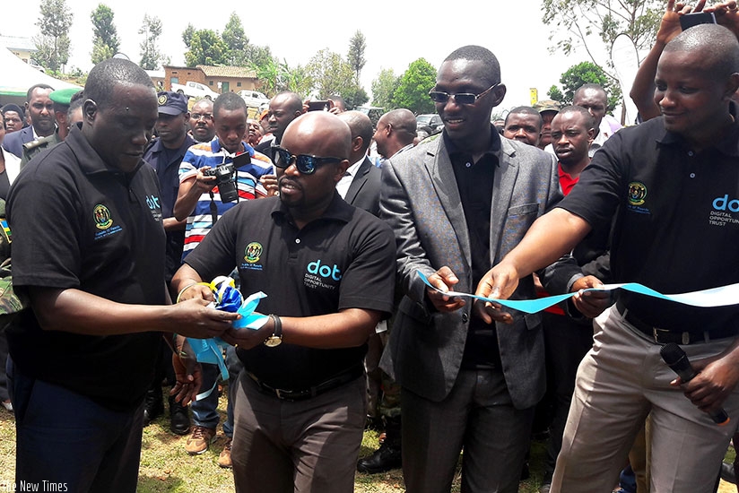 The Minister for ICT, Jean-Philibert Nsengimana (C), and Jean-Marie Vianney Gatabazi (L), the governor of Northern Province, cut a ribbon to launch the Tumba Smart Village Initiati....