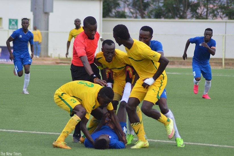 AS Kigali players attempt to lift a Rayon Sports player accusing him of time wasting during last season's first round clash as the referee intervenes to control the situation. / Sa....