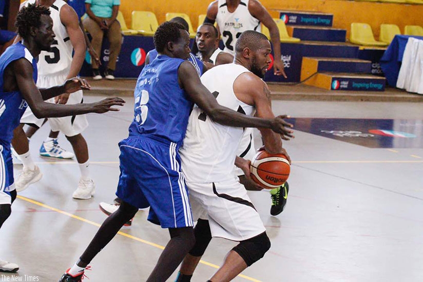 Patriots' Kami Kabenga (with ball) is blocked by a Hawusa players during the first half at Lugogo Indoor Arena on Sunday. Patriots won the game 110-43. Courtesy.